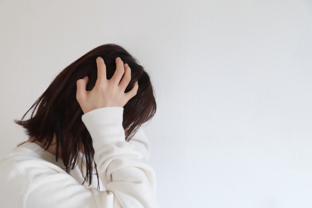 夜、自宅で物思いにふける女性
