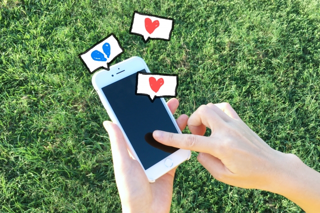 スマートフォンを見ながら複雑な表情を浮かべる女性