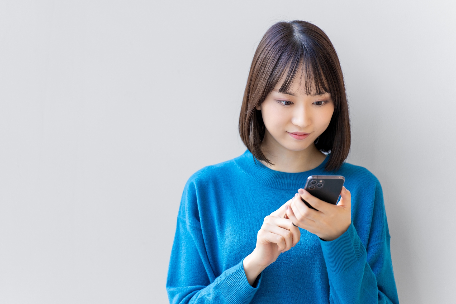 スマートフォンで婚活アプリを使う日本人女性